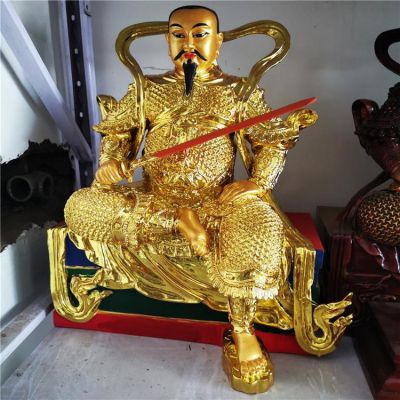 金色鎏金真武大帝銅像，單手持劍一腳盤坐一腳著地的真武祖師塑像